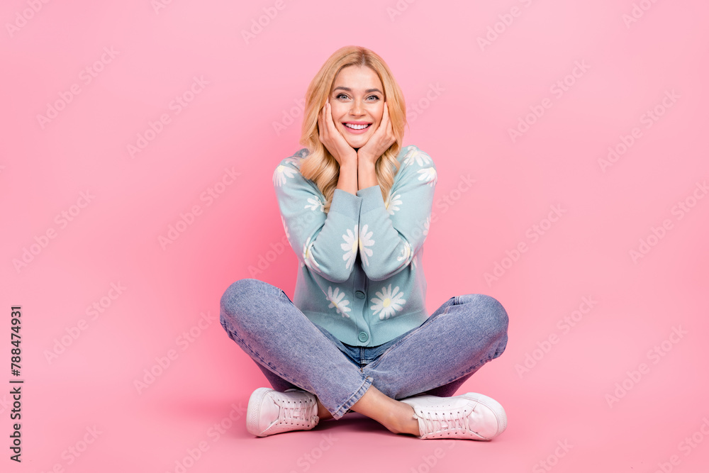 Full size photo of lovely young woman sit floor crossed legs dreamy dressed stylish flower print garment isolated on pink color background Full size photo of lovely young woman sit floor crossed legs dreamy dressed stylish flower print garment isolated on pink color background