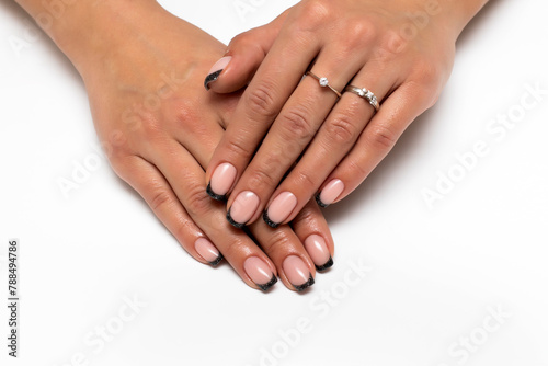 Tanned hands close-up. Black glitter French manicure on short square hands
