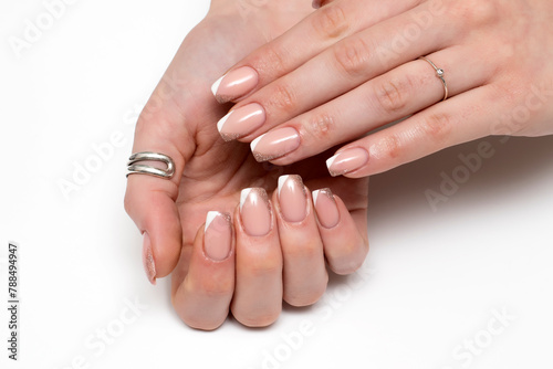 White beige shiny French manicure on short square nails close-up on a white background