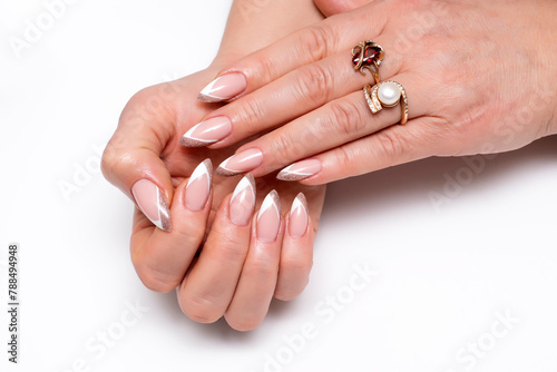 White sand shiny French manicure on sharp long nails on a white background close-up.