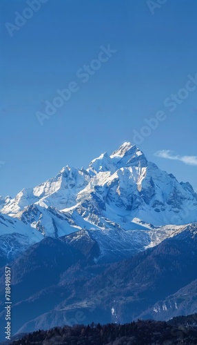 Mountain Peaks Snow-capped mountain peaks under a clear blue sky, offering a majestic and serene background