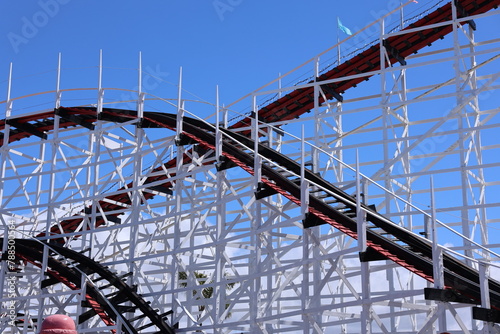 old fashioned wood roller coaster against a blue sky