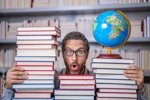 school teacher with book in classroom. teacher in classroom. Teachers Day. Tutor at classroom. Man geographer with books in classroom. Knowledge and education concept. Devouring books photo