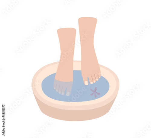 Foot bath with natural floral elements. Beauty salon and foot bath. Female legs during massage.