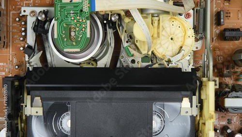 Insert the video VHS cassettes into the VCR, play and rewind and eject cassettes in 4K. Top view. photo