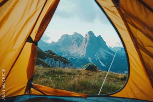 View from inside a tent revealing a majestic mountain landscape at dawn.