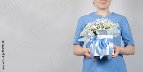 The doctor holds a bouquet of flowers, a place for text. Happy Doctors Day.