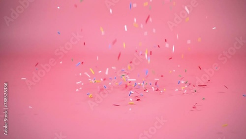 colorful sprinkles falling on pink background, decoration for cake and bakery, slow motion