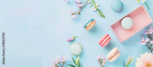 Macarons and flowers on a blue surface 