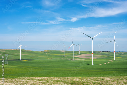 Wind turbines and green agricultural landscape seen in Italy