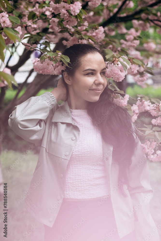 A young beautiful girl is photographed outdoors in a flowering tree A young beautiful girl is photographed outdoors in a flowering tree