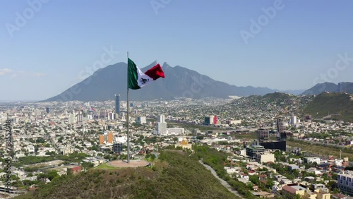 Aerial Forward Shot Of Tall Flag At Mirador Del Obispado On Hill In City - Monterrey, Mexico photo