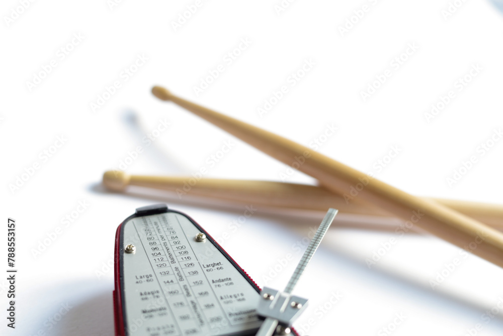 a pair of wooden drumsticks and a metronome a pair of wooden drumsticks and a metronome