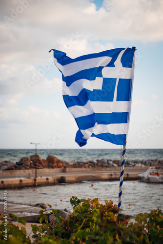 Greek flag on wall near sea on Crete island