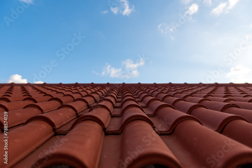 Red tile roof under blue sky. One part is a roof and the other is a pure blue sky.