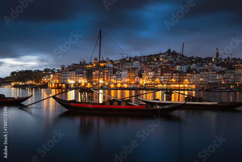 Porto, Portugal old town on the Douro River with traditional rabelo boats at night. With wine barrels from the port on the Douro River, Ribeira I in the background, Porto, Portugal. photo