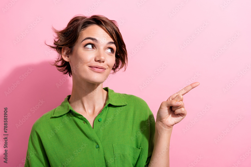 Photo portrait of lovely young lady point look empty space wear trendy green garment isolated on pink color background Photo portrait of lovely young lady point look empty space wear trendy green garment isolated on pink color background