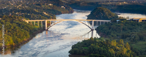 Border between Brazil and Paraguay and connects Foz do Iguaçu to Ciudad del Este. Ponte da Amizade in Foz do Iguaçu. Aerial view of the Friendship Bridge with Paraná river.. photo