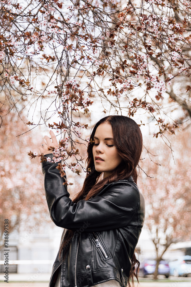 A young beautiful girl is photographed outdoors in a flowering tree