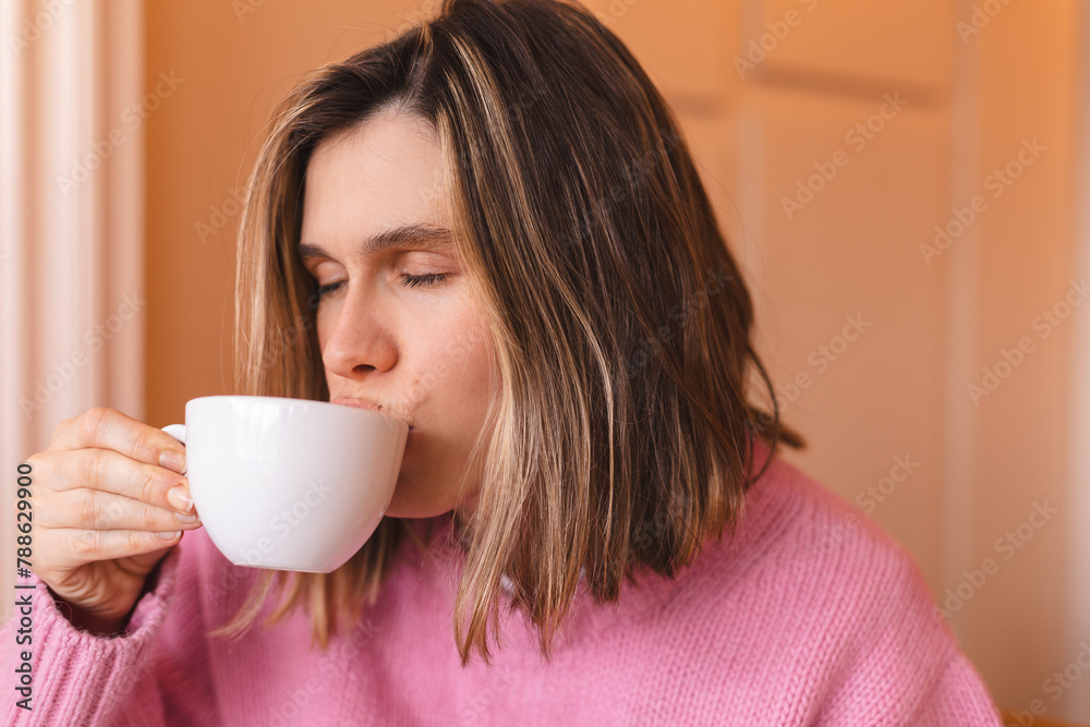 Thoughtful blonde woman drinking coffee in cafe, lifestyle, coffee, communication and local business, unaltered. Sensual woman with closed eyes. Girl wear pink sweater. Thoughtful blonde woman drinking coffee in cafe, lifestyle, coffee, communication and local business, unaltered. Sensual woman with closed eyes. Girl wear pink sweater.