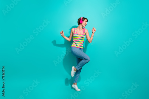 Full body portrait of cheerful pretty lady good mood dancing listen favorite song isolated on turquoise color background