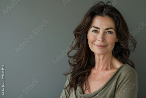 A woman with long dark hair is smiling for the camera