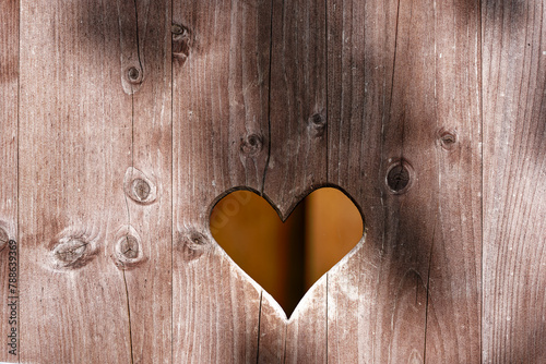 Close-up of heart hole in wooden door of outdoor toilet at Swiss City of Wallisellen on a sunny spring day. Photo taken April 18th, 2024, Wallisellen, Canton Zürich, Switzerland.