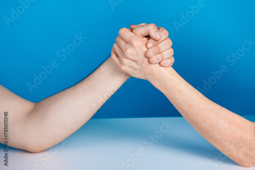 Photo of two mature young people arms wrestling fight sport businesspeople isolated blue color background