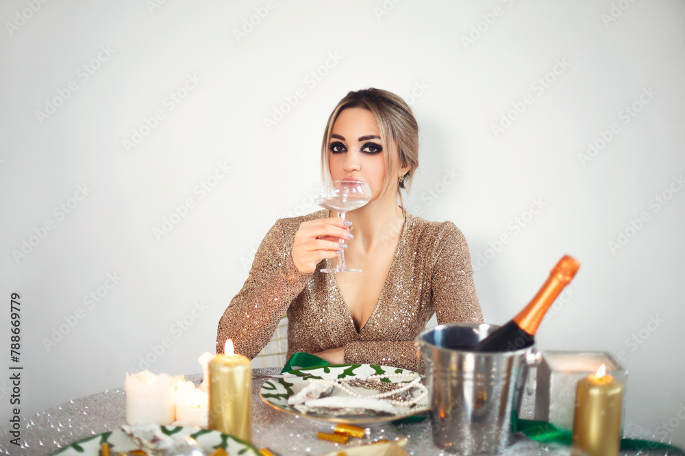 Young attractive elegant woman wearing sparkly sequin dress enjoying Christmas dinner alone at home Young attractive elegant woman wearing sparkly sequin dress enjoying Christmas dinner alone at home