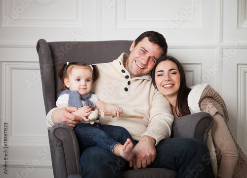 Smiling family with one year old baby girl indoor © Dasha Petrenko
