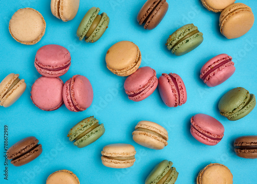 Multicolored macarons on a blue background, top view, dessert