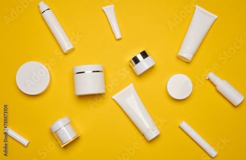 Various types of white plastic packaging, bottle, jar, tube on a yellow background. Container for cosmetics
