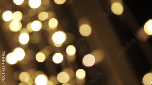 Festive black Christmas background made of glowing defocused garland with many lights. Concept of New Year celebration. Copy space for your design