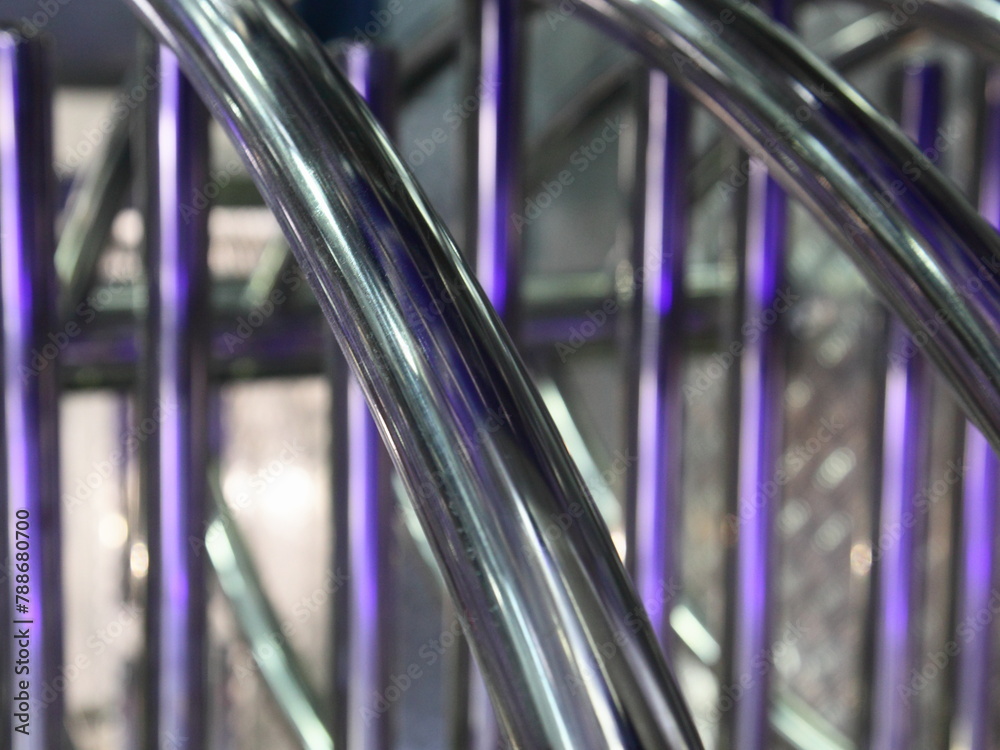 industrial abstract shiny metal spiral background with vertical and diagonal chrome pipe lines
