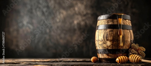 Wooden barrel filled with honey placed on a wooden surface against a dark background. Close-up image with empty space for text. photo