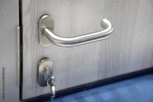Metal door handle and lock with key on door closeup