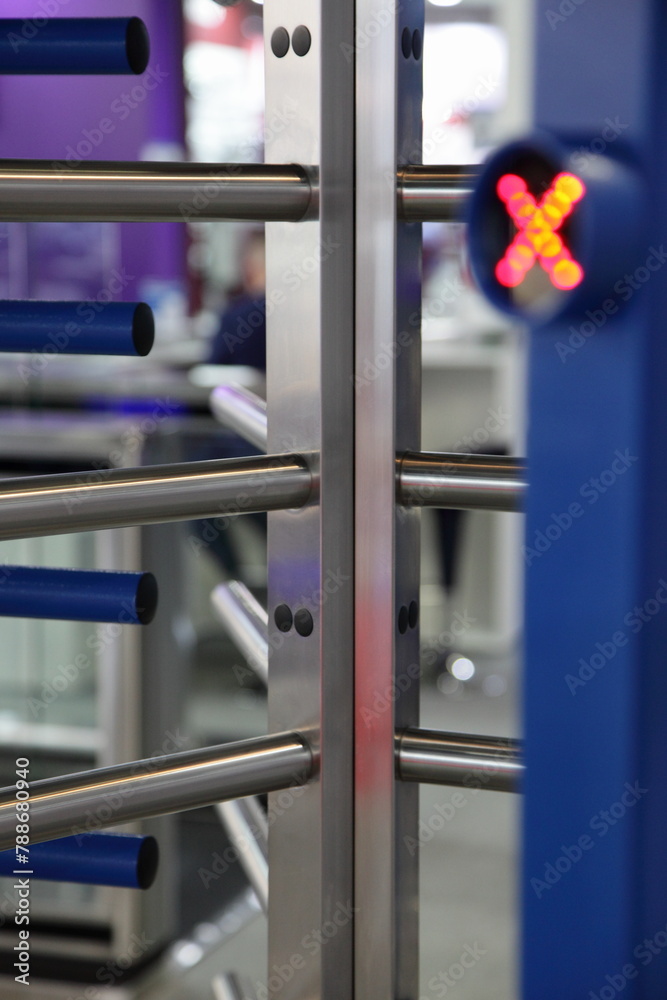 Doorway turnstile barrier with blurred lighting Red cross sign - no entrance