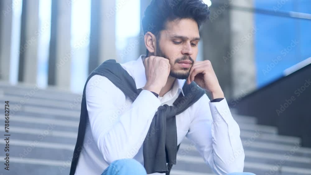 Worried stressed bearded man entrepreneur sitting on stairs feeling bad about losing job financial crisis failure with deal overworked or mental health problem at modern business centre outdoors alone Worried stressed bearded man entrepreneur sitting on stairs feeling bad about losing job financial crisis failure with deal overworked or mental health problem at modern business centre outdoors alone