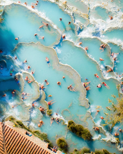 Aerial view of turquoise ocean with sunbathers at Saturnia spa, Cascate del Mulino, Hot Spring, Manciano, Italy. photo