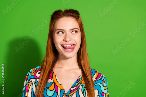 Photo portrait of attractive woman tongue lick teeth lips look empty space dressed stylish retro clothes isolated on green color background
