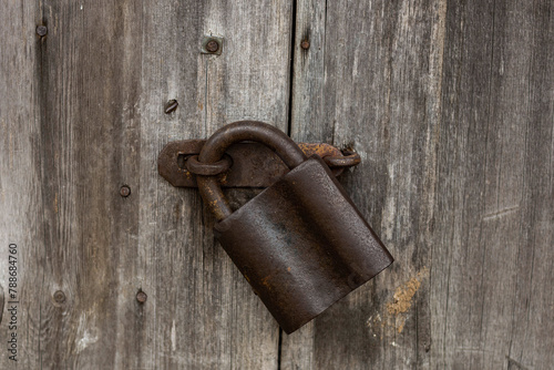 an old lock on the door of a wooden building