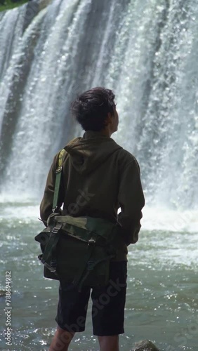 Asian man vacationing alone at the Sabo Dam artificial waterfall which has 6 levels. The rear view of a man is enjoying the beautiful panorama of Sabo Dam which has 6 levels of water photo
