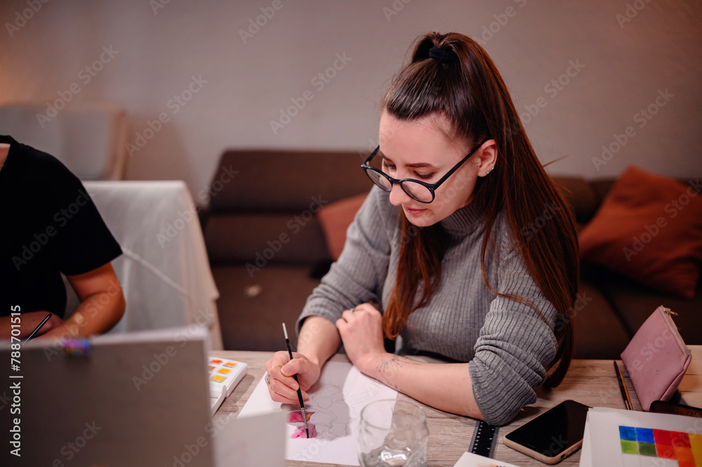 Two artists engage in a collaborative discussion over a watercolor palette, with one offering guidance as they navigate the hues together. Two artists engage in a collaborative discussion over a watercolor palette, with one offering guidance as they navigate the hues together.