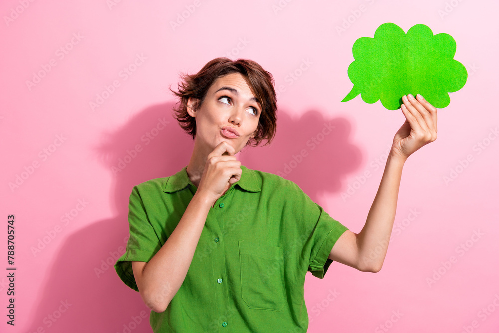 Photo portrait of attractive woman hold paper cloud look thoughtful wear trendy green clothes isolated on pink color background Photo portrait of attractive woman hold paper cloud look thoughtful wear trendy green clothes isolated on pink color background