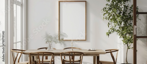 Blank picture frame hung on a white wall in a charming dining room with Danish design aesthetics.