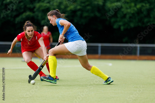 Young field hockey player leading the ball in attack. © skumer