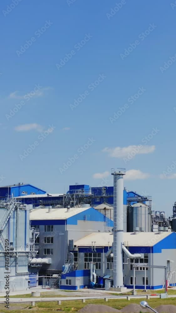 Modern warehouse under blue sky. Steel grain elevators for grain storage. Agriculture industry. Innovative plant for agribusiness. Vertical video Modern warehouse under blue sky. Steel grain elevators for grain storage. Agriculture industry. Innovative plant for agribusiness. Vertical video