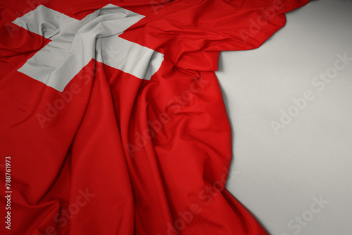 waving national flag of switzerland on a gray background.