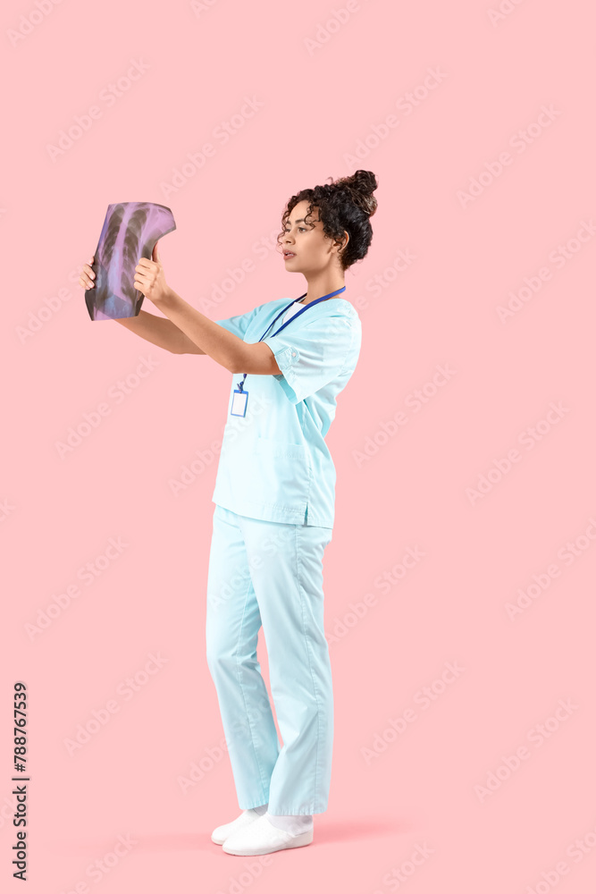 Female African-American medical intern with x-ray image of lungs on pink background Female African-American medical intern with x-ray image of lungs on pink background