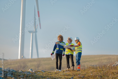 A team of engineers and workers oversees a wind turbine project at a modern wind farm, working together to ensure the efficient generation of renewable energy